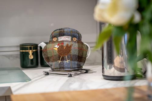 圣安德鲁斯Market Street No 28a - St Andrews的柜台上放着一个花瓶，旁边是一朵花。