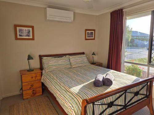 ein Schlafzimmer mit einem Bett mit zwei Schuhen drauf in der Unterkunft Entire house near North Lakes, Brisbane, Australia in Griffin