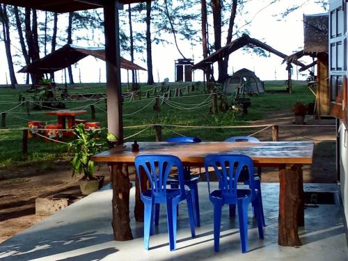 ein Holztisch mit zwei blauen Hockern drumherum in der Unterkunft Baan Boon Beach Bungalow in Ban Nok Na