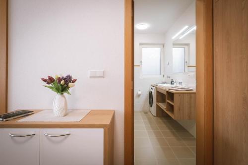 eine Küche mit einer Vase mit Blumen auf einer Theke in der Unterkunft dolomites view apartment in Oberrasen