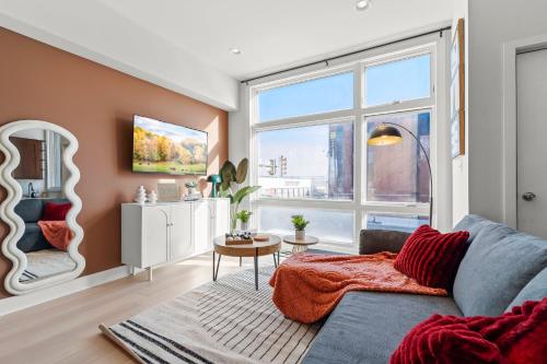 a living room with a couch and a large window at Modern 1BR Apartment Downtown Philly Near MET in Philadelphia