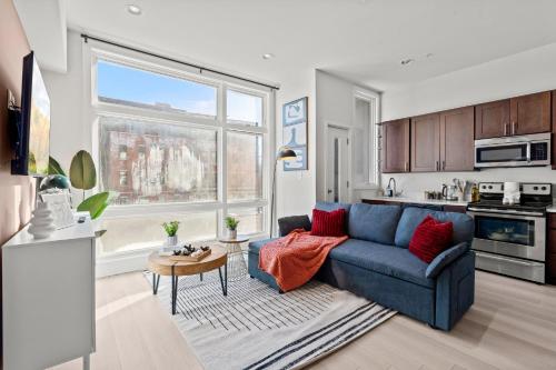 a living room with a blue couch and a kitchen at Modern 1BR Apartment Downtown Philly Near MET in Philadelphia