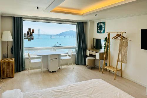a bedroom with a desk and a large window at 유니크 in Busan