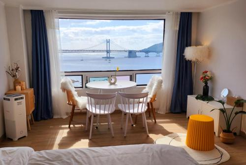 a room with a table and chairs and a view of a bridge at 유니크 in Busan
