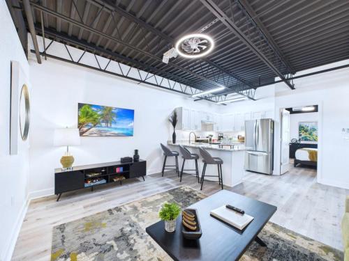 a living room with a table and a kitchen at Chic Loft Retreat Near Port Canaveral -Unit 202 in Cape Canaveral