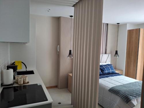 une petite chambre avec un lit et une cuisine dans l'établissement Oma Deluxe, à Hacienda Carolina