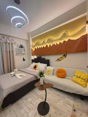 a hotel room with a bed and a couch at The Fyangz Luxe Staycation Near Anjo World in Cebu