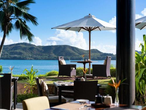 ein Restaurant mit Blick auf das Meer in der Unterkunft Raffles Seychelles in Baie Sainte Anne