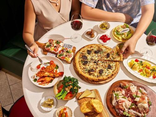 a group of people sitting at a table with plates of food at Fairmont Singapore in Singapore