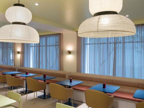 ein Restaurant mit Tischen und Stühlen und großen Fenstern in der Unterkunft ibis Styles Sydney Central in Sydney