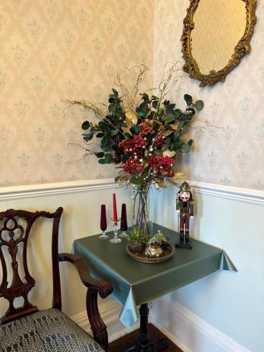 einen Tisch mit einer Vase aus Blumen und einem Spiegel in der Unterkunft The Angove - Adults Only in Weymouth