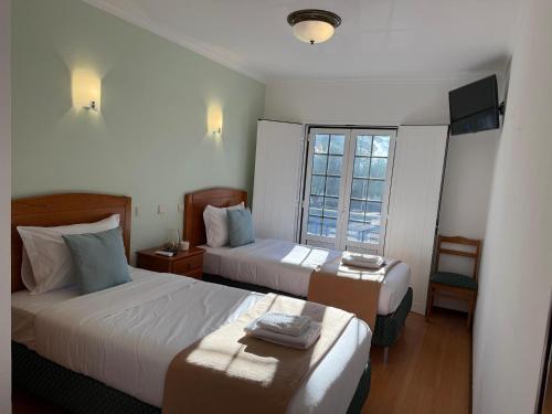 Postel nebo postele na pokoji v ubytování Hospedaria Canto do Rossio