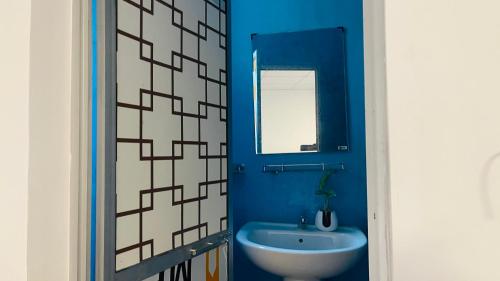 ウェリガマにあるWave Nest Hotelの青いバスルーム(シンク、鏡付)