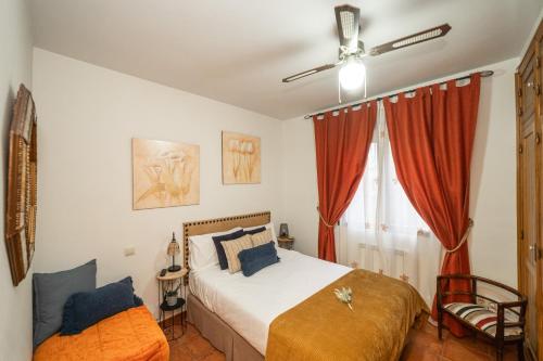 une chambre avec deux lits et un ventilateur de plafond dans l'établissement La Casita de La Aduana, à Candeleda