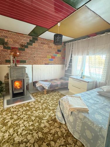 ein Schlafzimmer mit einem Kamin, einem Bett und einem Kamin in der Unterkunft Wiire old fishermans farmhouse and smoke sauna in Saulepa