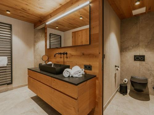 a bathroom with a sink and a mirror at Almrausch Lech Apartments in Lech am Arlberg