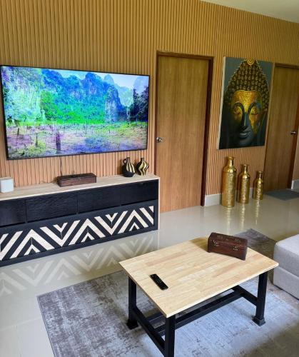 a living room with a tv and a coffee table at Zout Villas in Thong Sala