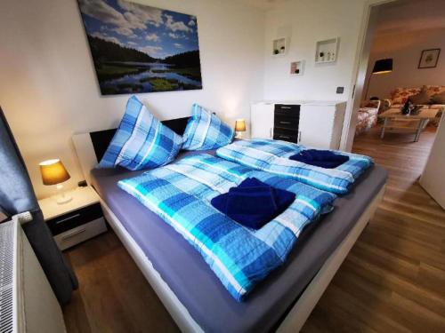 ein Schlafzimmer mit einem blau-weißen Bett mit Kissen in der Unterkunft Ferienwohnung Neuerer in Riedlhütte