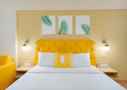 1 dormitorio con 1 cama grande y cabecero amarillo en Bloom Hotel - Whitefield, en Bangalore