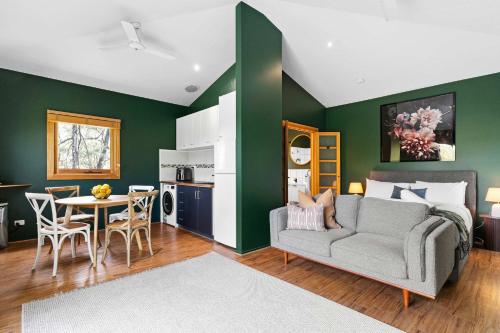 uma sala de estar com um sofá e uma mesa em Central studio with spabath em Daylesford