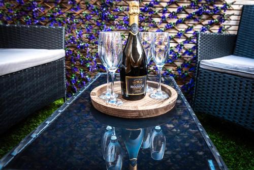 a bottle of wine on a table with two wine glasses at Open Mind Property - 4 BR, Hot Tub & Free Parking in Portsmouth