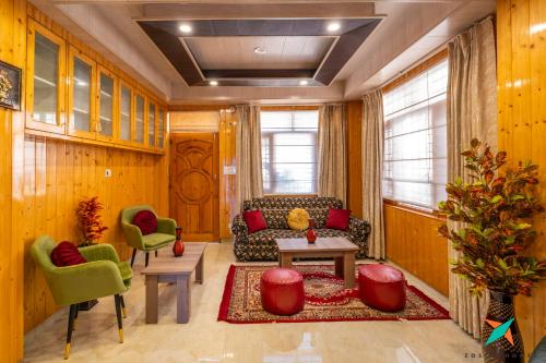 a living room with a couch and a table and chairs at Zostel Homes Shoghi, Shimla in Shogi