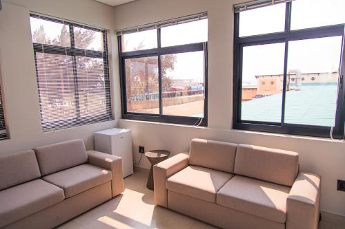 ein Wohnzimmer mit 2 Sofas und 2 Fenstern in der Unterkunft Waterfront Apartment in Lüderitz