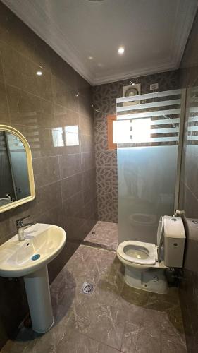 a bathroom with a toilet and a sink at شقق الحمراء 1 in Quai