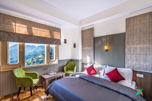 a bedroom with a bed and a desk and chairs at Zostel Homes Shoghi, Shimla in Shogi