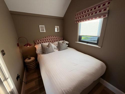 ein Schlafzimmer mit einem großen weißen Bett mit einem Fenster in der Unterkunft Water Cabin With Water Sports Equipment and Bikes, Bath in Bristol