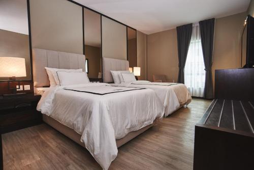 a hotel room with two beds and a large mirror at Corsica Hotel in Kulai