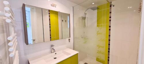 une salle de bain avec un lavabo et un miroir dans l'établissement Charmante villa entièrement rénovée, dans le centre du village, à La Couarde-sur-Mer