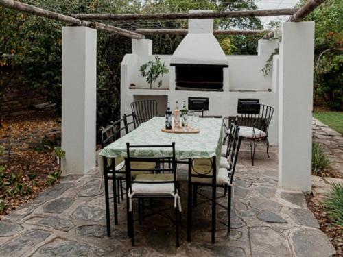 a table and chairs sitting under a pergola at Karoo Cypress Guesthouse in Graaff-Reinet