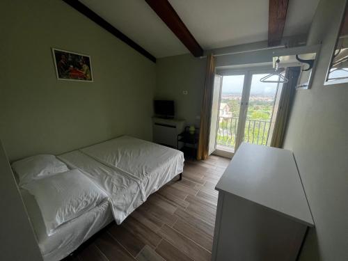 une petite chambre avec un lit et une fenêtre dans l'établissement Villa Wuthering Heights, à Grottaferrata