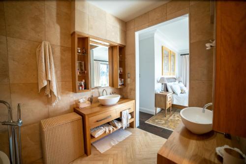 ein Badezimmer mit zwei Waschbecken und einer Badewanne in der Unterkunft Yuruga, Exeter in Exeter