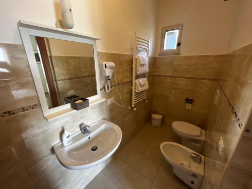 une salle de bain avec un lavabo, des toilettes et un miroir dans l'établissement Villa Wuthering Heights, à Grottaferrata