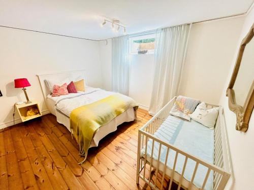 ein Schlafzimmer mit einem Bett und einem Kinderbett in der Unterkunft Traditional House In Old Viken in Viken