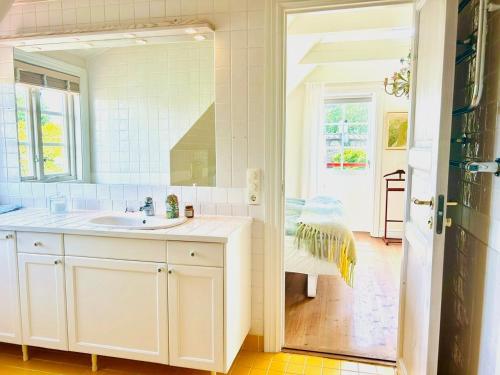 ein weißes Badezimmer mit Waschbecken und Spiegel in der Unterkunft Traditional House In Old Viken in Viken