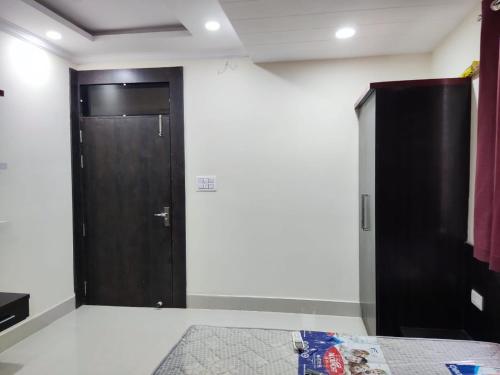a room with a black door and a white wall at Shubham guest house in Gwalior