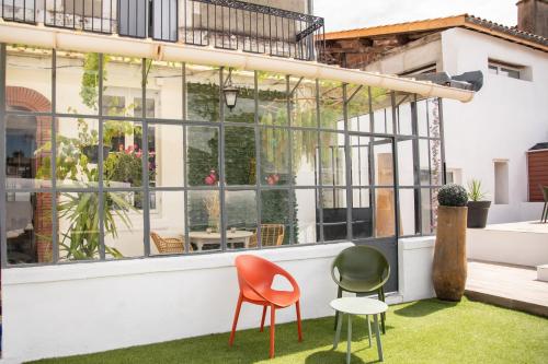 eine Terrasse mit zwei Stühlen und einem Tisch in der Unterkunft La Boissière - Chambre d'hôtes premium in Sainte-Bazeille