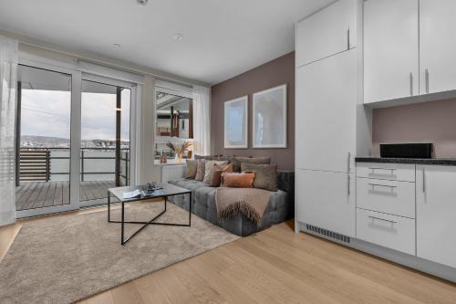 ein Wohnzimmer mit Sofa und Tisch in der Unterkunft Northstay - Cozy Arctic Apartment, Free Parking in Tromsø