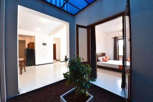 a room with a mirror and a bedroom with a bed at Villa Serein - Garden Suite in Galle