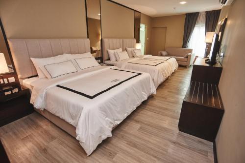 a hotel room with two beds and a television at Corsica Hotel in Kulai