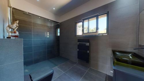 une salle de bain avec une douche avec un banc et un lavabo dans l'établissement Casamea - Villa Familiale, Piscine chauffée, Clim, à Ajaccio