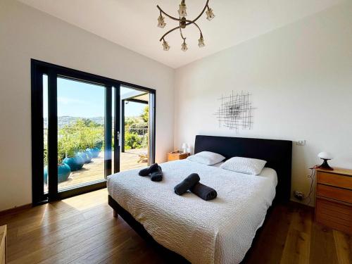 une chambre avec un grand lit avec une grande fenêtre dans l'établissement Casamea - Villa Familiale, Piscine chauffée, Clim, à Ajaccio