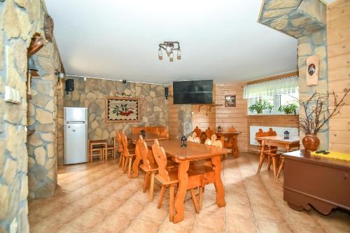 Tatrzańska Kotwica في فيتوف: مطبخ وغرفة طعام مع طاولة وكراسي