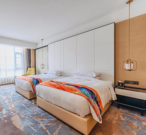 una camera d'albergo con due letti e una grande finestra di Xi'an Liban Hotel a Xi'an