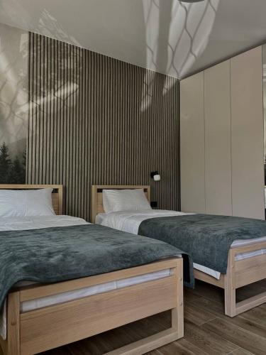 two beds sitting next to each other in a bedroom at Апарт-готель "Модерн 24" in Netishyn