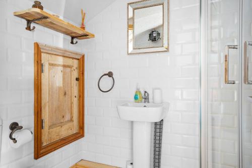 een badkamer met een wastafel en een douche bij Porth Chapel in Newlyn