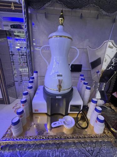 un mixeur blanc posé sur une table avec des tasses dans l'établissement فندق قصر ماريوت 1, à Al ‘Azīzīyah